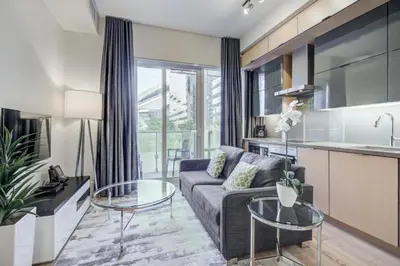 a living room with a couch and a table at Skyline Suites - Walk to MTCC, ACC, Rogers Centre & Entertainment District in Toronto