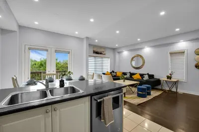 a kitchen with a sink and a living room at Spacious Family Friendly Vacation home in Brampton