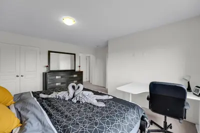 a bedroom with a bed and a desk and a chair at Spacious Family Friendly Vacation home in Brampton
