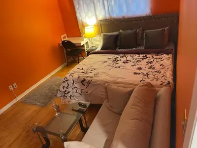 a bedroom with a bed and a couch and a table at Travelers Home in Oshawa