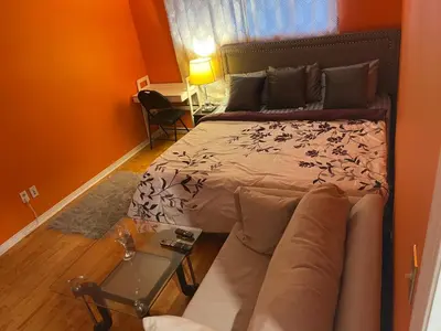 a bedroom with a bed and a couch and a table at Comfort Quest in Oshawa