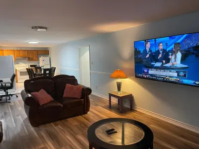 a living room with a couch and a flat screen tv at Comfort Quest in Oshawa