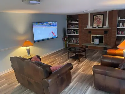 a living room with a couch and a flat screen tv at Comfort Quest in Oshawa