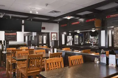 a restaurant with tables and chairs and a bar at Travelodge by Wyndham Cambridge - Waterloo in Preston