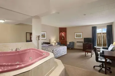 a large bathroom with a pink tub in a hotel room at Travelodge by Wyndham Cambridge - Waterloo in Preston