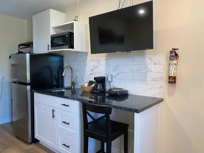 a kitchen with a black counter and a refrigerator at Motel 400 & Suites in Innisfil