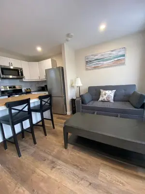 a living room with a couch and a kitchen at Motel 400 & Suites in Innisfil