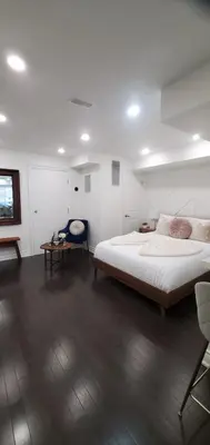 a white bedroom with a large bed and a table at Dufferin Serenity Suite in Toronto