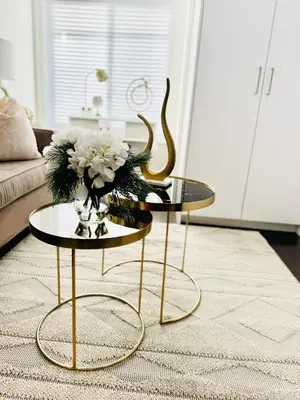two tables in a living room with a vase of flowers at Dufferin Serenity Suite in Toronto