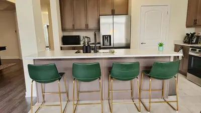 a kitchen with a counter with four green bar stools at 5beds 2800 sqft house, sleeps 11, 18 mins to falls in Thorold