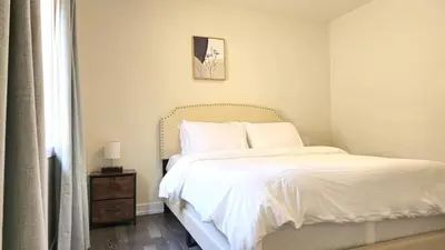a bedroom with a bed with white sheets and a window at 5beds 2800 sqft house, sleeps 11, 18 mins to falls in Thorold