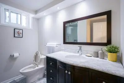 a bathroom with a sink and a toilet and a mirror at 1,200sq ft comfy home, perfect location, luxury bedding, feels like home! in Mississauga