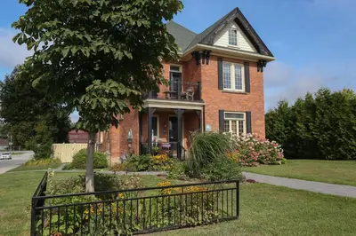 a brick house with a gate in front of it at Danby House in Markdale