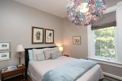 a bedroom with a large bed and a chandelier at Danby House in Markdale