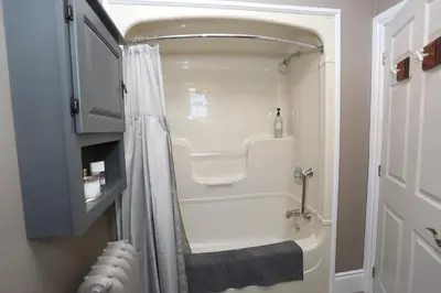 a white bathroom with a shower and a sink at Danby House in Markdale