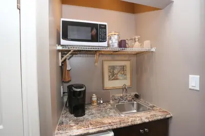 a kitchen with a sink and a microwave on a shelf at Danby House in Markdale