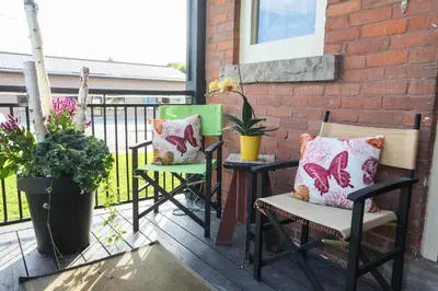 two chairs and a table on a balcony with plants at Danby House in Markdale