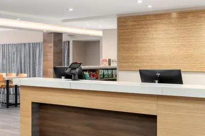an office lobby with a reception desk with two laptops at Home2 Suites By Hilton Kitchener in Kitchener
