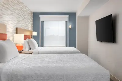 a hotel room with two beds and a flat screen tv at Home2 Suites By Hilton Kitchener in Kitchener