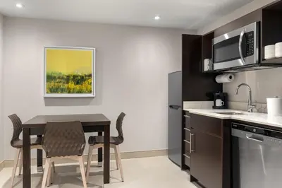 a kitchen with a table and chairs in a room at Home2 Suites By Hilton Kitchener in Kitchener