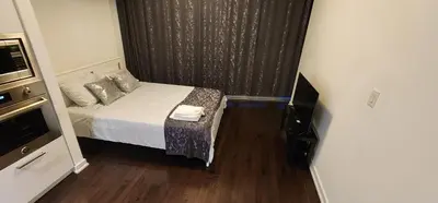 a small room with a bed and a television at Modern studio High Floor ,CN Tower, ScotiaArena in Toronto