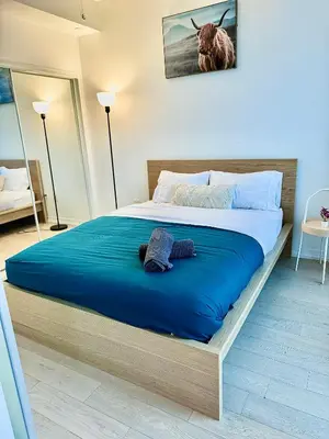 a bedroom with a large bed with blue sheets at Elegant Condo Near Eaton Centre Mall in Toronto