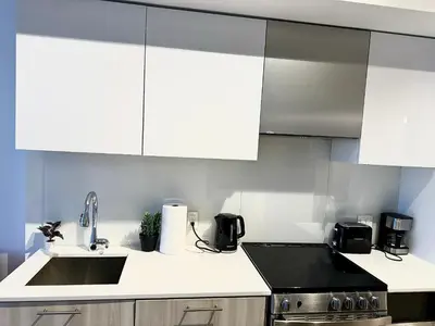 a kitchen with white cabinets and a sink at Elegant Condo Near Eaton Centre Mall in Toronto
