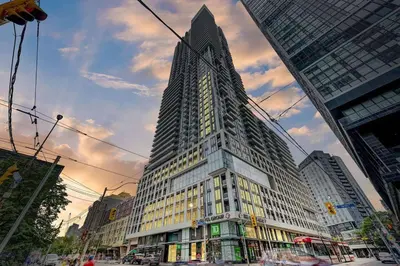 a tall building in the middle of a city at Elegant Condo Near Eaton Centre Mall in Toronto
