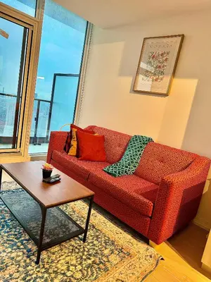 a living room with a red couch and a table at Elegant Condo Near Eaton Centre Mall in Toronto
