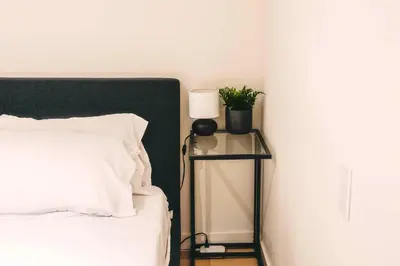 a bedroom with a bed and a table with a lamp at Lum The Queen in Toronto