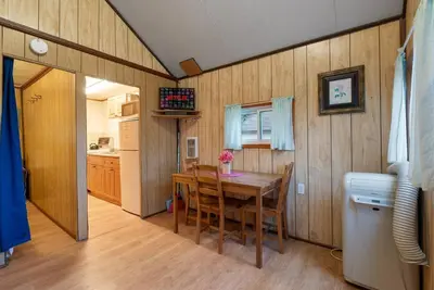 a dining room with a wooden table and a kitchen at Enjoy Rice Lakes in Bailieboro
