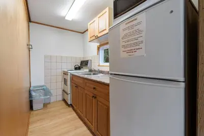 a kitchen with a white refrigerator and wooden cabinets at Enjoy Rice Lakes in Bailieboro