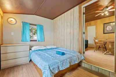 a bedroom with a bed and a dining room at Relaxing Lakefront Cabin in Bailieboro