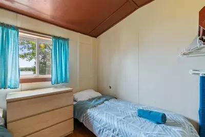 a small bedroom with a bed and a sink at Relaxing Lakefront Cabin in Bailieboro