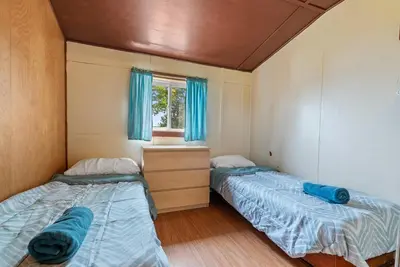 two beds in a small room with a window at Relaxing Lakefront Cabin in Bailieboro