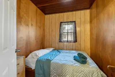 a small bedroom with a bed and a window at Relaxing Lakefront Cabin in Bailieboro
