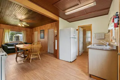 a kitchen with a table and a white refrigerator at Relaxing Lakefront Cabin in Bailieboro
