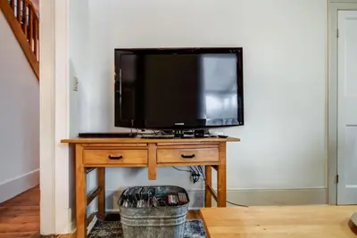 a television sitting on a wooden table in a room at The Marigold - Gorgeously remodelled PEC farmhouse in West Lake