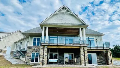 a large house with a balcony on top of it at Lakeside Maison in Hillier