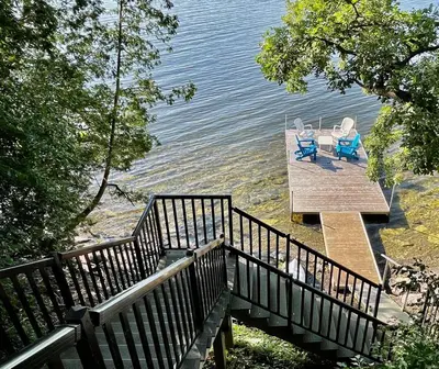 a dock with two chairs sitting on top of the water at Lakeside Maison in Hillier