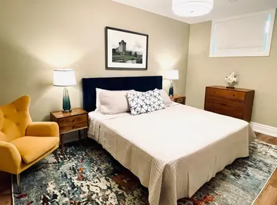 a bedroom with a bed and a chair at Lakeside Maison in Hillier