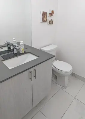 a bathroom with a white toilet and a sink at KozyStay Toronto in Toronto