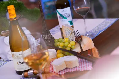a table with a bottle of wine and cheese and grapes at L'auberge De France Inn in Belleville