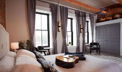 a bedroom with a bed with a table on it at L'auberge De France Inn in Belleville