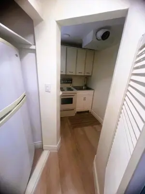 a small kitchen with white cabinets and a stove at Millpond Basement Units in Richmond Hill