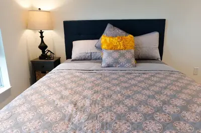 a bed with a blue headboard and pillows on it at 2bhk Luxury brand new pvt suite Kitchener in Kitchener