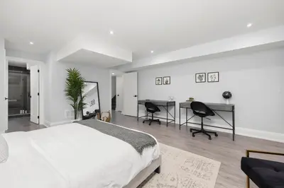 a bedroom with a bed and a desk and chairs at Cozy Modern Custom Built-Free Pkg-Game Room-Heated Floors in Toronto