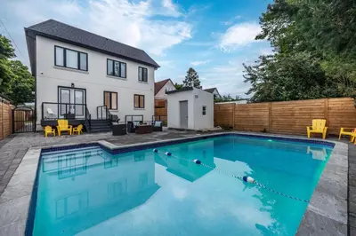 a swimming pool in front of a house at Cozy Modern Custom Built-Free Pkg-Game Room-Heated Floors in Toronto