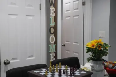 a dining room table with a chess board and a vase of flowers at Garden 2 BR Apt - Free Parking Wifi Laundry Workstation in Brampton