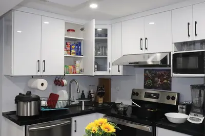 a kitchen with white cabinets and a black counter top at Garden 2 BR Apt - Free Parking Wifi Laundry Workstation in Brampton